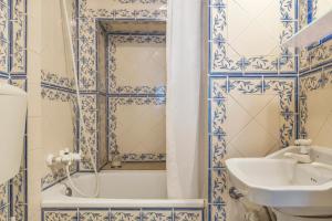 a bathroom with blue and white tiled walls and a sink at Romantic Apartment + Tejo River View in Lisbon +6 photos