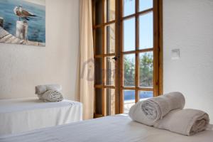 Cette chambre comprend un lit et une fenêtre avec des serviettes. dans l'établissement Villa Puig Rosell, à Calonge 38 autres photos