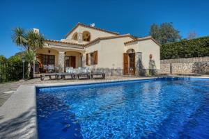 une villa avec piscine devant une maison dans l'établissement Villa Puig Rosell, à Calonge