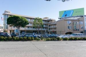 a parking lot with cars parked in front of a building at Francisco Bay Inn in San Francisco