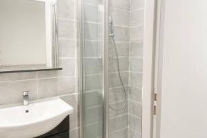 La salle de bains est pourvue d'une douche et d'un lavabo. dans l'établissement Saint Etienne Studio Lot 3, à Toulouse