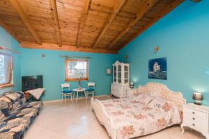 a bedroom with blue walls and a bed and a couch at Apartments Borik Crikvenica in Crikvenica
