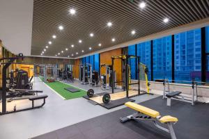 a gym with treadmills and machines in a building at Wyndham Xinyang Downtown in Xinyang