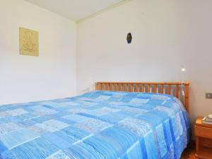 a bedroom with a bed with a blue comforter at Apartment Cesa Palua by Interhome in Alba di Canazei