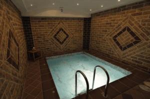 a bath tub in a room with a brick wall at Panorama Spa Hotel in Ouranoupoli