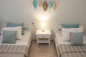ein Schlafzimmer mit 2 Betten und einem Tisch mit einer Lampe in der Unterkunft Tramontana House1 in Skiathos-Stadt