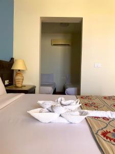 a hotel room with a bed with a towel on it at ONATTI Beach Resort in Quseir