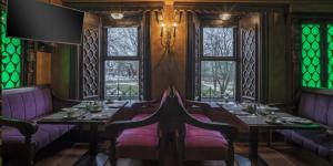 a dining room with purple chairs and tables and windows at Skeffington Arms Hotel in Galway