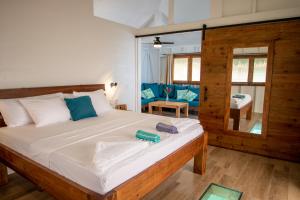 a bedroom with a large white bed with blue pillows at Sol Bungalows Bocas del Toro in Bocas Town