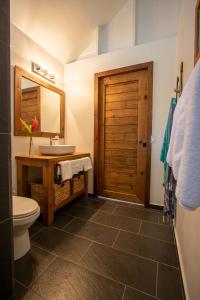 a bathroom with a sink and a toilet and a mirror at Sol Bungalows Bocas del Toro in Bocas Town