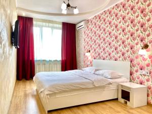 a bedroom with a bed with a pink floral wallpaper at ApartPoltava Вишукані апартаменти, 2-ОКРЕМІ КІМНАТИ, квартира в НОВОМУ будинку, Банківський ЧЕК in Poltava