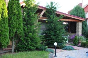 a house with two evergreen trees in the yard at Villa Costa in Sanzhiyka