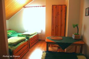 a bedroom with two beds and a table in it at Noclegi na Drzewie in Cisna