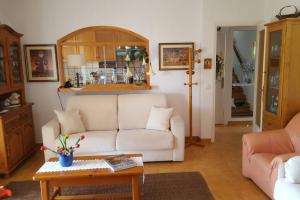 een woonkamer met een witte bank en een tafel bij Casa Almadrava in Roses