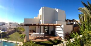 ein weißes Haus mit einer Terrasse und einem Pool in der Unterkunft Villa in Spain at Las Colinas Golf & Country Club in Orihuela