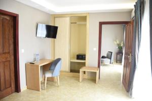 a hotel room with a desk and a television in a room at Hotel Royal Palace in Douala