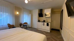 a hotel room with a bed and a kitchen at Casa Cappuccino duo studio in Groningen