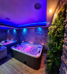 una vasca idromassaggio in una stanza con luci viola di Glamour Wellness Apartments a Zagabria