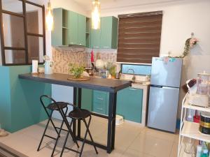 La cuisine est équipée d'une table, de deux chaises et d'un réfrigérateur. dans l'établissement Letstay De Casa, à Ipoh