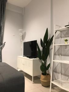 una camera da letto con TV su un mobile bianco con una pianta di Letstay De Casa a Ipoh