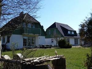 uma casa verde e branca com uma cerca em frente em Dorfstr_ OT Mueggenburg em Klein Kirr