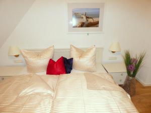 a bed with pillows on it in a bedroom at Lindenstrasse Haus Sonnenrose in Zingst