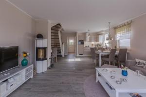 a living room and dining room with a tv and a kitchen at Birkmaase 1 a _Abendklang_ in Zingst