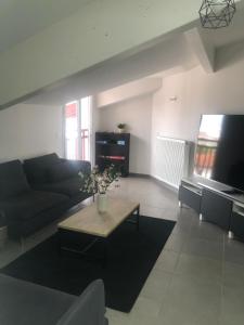 een woonkamer met een bank en een salontafel bij Appartement spacieux et moderne - Tout confort in Hendaye