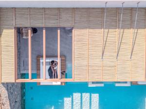 a dog looking out of a window next to a swimming pool at Malvezzino Luxury Villas in Palaiokastro