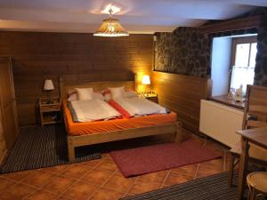 a bedroom with a bed in a wooden wall at Apartmány Chalupinka in Železná Ruda