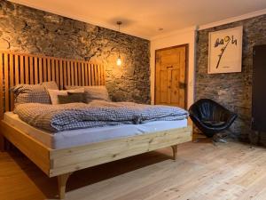 1 dormitorio con 1 cama y 1 silla negra en Ferienhaus Krieben, 