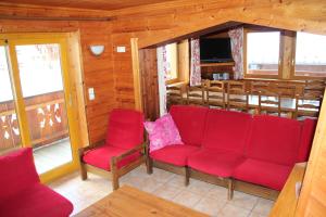 a living room with red chairs and a tv at Chalet 1 La Forestière Les Gets in Les Gets
