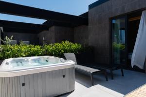 un bain à remous et un banc sur une terrasse dans l'établissement Modica Boutique Hotel, à Modica