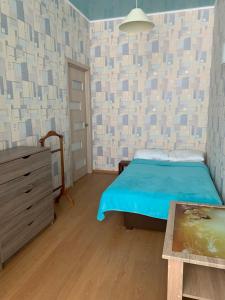 a bedroom with a bed and a dresser in it at Town-house Golden Bugaz in Karolino-Buhaz
