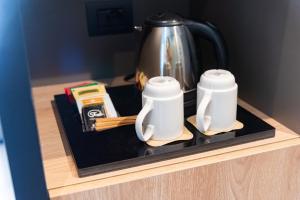 a tea pot and two cups sitting on a counter at Modica Boutique Hotel in Modica
