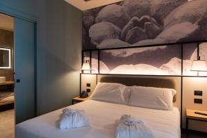 een slaapkamer met een bed met handdoeken erop bij Modica Boutique Hotel in Modica