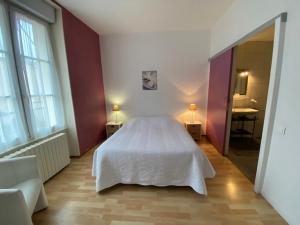 1 dormitorio con cama blanca y baño en Pension Gérard en Bourbonne-les-Bains