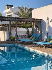 a swimming pool with two blue chairs next to a building at One Thousand Waves in Moraira