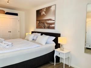 a bedroom with a bed with white sheets and pillows at Haus Strandbummler im Ostseebad Baabe in Baabe