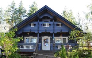 a blue wooden house with a white door at Ilmajärvi Cottage in Ruokolahti