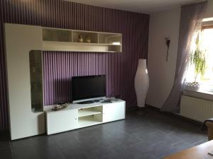 a living room with a television on a white cabinet at Ferienhaus Karin in Erfde