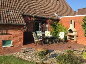 Un patio con una mesa y sillas frente a una casa. en Ferienhaus Karin, en Erfde