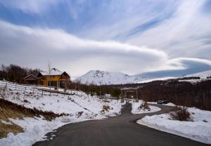 a road in the snow with a house and a mountain at N'Bjeshke te guri i zi in Prizren