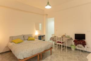 1 dormitorio con cama, mesa y TV en Archita Guest House, en Bari