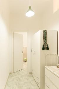 cocina blanca con puerta a un baño en Archita Guest House, en Bari