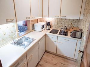 a small kitchen with a sink and a microwave at Haus Ferienglück in Ramsau am Dachstein
