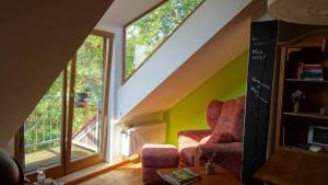 ein Wohnzimmer mit einem Stuhl und einem Fenster in der Unterkunft RuheOase mit Baumkronenblick in Naundorf