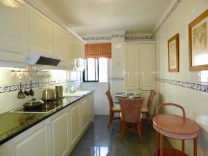 Una cocina con gabinetes blancos y una mesa y sillas. en Downtown by Check-in Portugal, en Faro