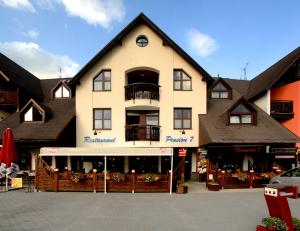 un grande edificio con un balcone in cima di Wellness Pension 7 a Harrachov