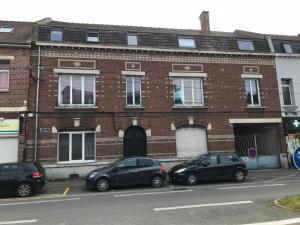 twee auto's geparkeerd voor een bakstenen gebouw bij Au Studio 36 Arras avec parking privé in Arras